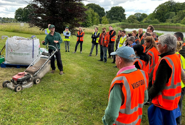 wildflower turf bng team meeting stood in a circle having a talk.